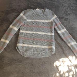 Grey sweater with white and pink stripes.